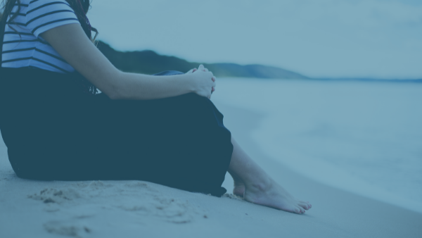  A woman is sitting on a beach. 
