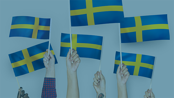  Käsiä, jotka pitelevät Ruotsin lippuja. 